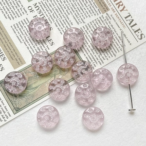 Detailed macro view of pink translucent Czech glass beads with celestial moon and star relief