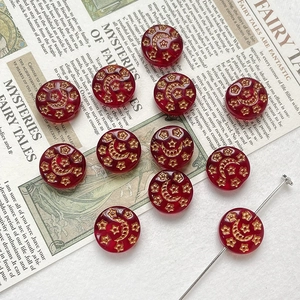 Macro detail of red celestial beads with gold moon and star patterns on vintage paper