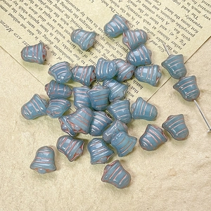 Macro shot of blue Czech glass bell beads with vintage copper stripes for DIY jewelry making
