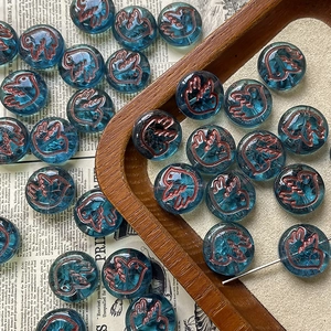 Detail of blue Czech glass beads with hand-painted bird motifs for DIY jewelry