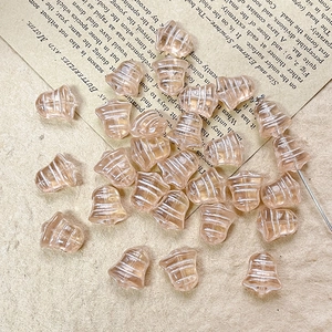 Macro shot of champagne gold bell-shaped Czech glass beads with hand-painted white stripes