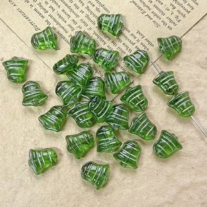 Macro view of green transparent bell-shaped glass beads with silver decorative lines