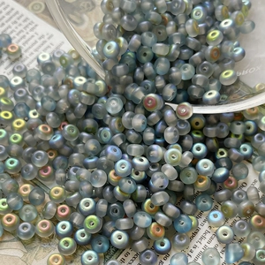 Macro view of blue frosted iridescent glass seed beads scattered on vintage newspaper