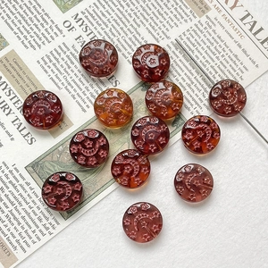 Detail of amber Czech glass beads with hand-painted star and moon patterns for DIY jewelry