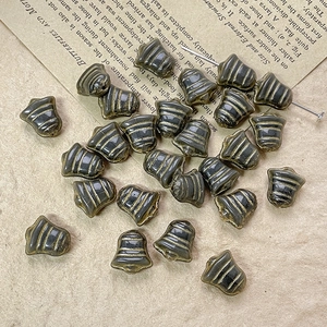 Macro shot of vintage bell-shaped Czech glass beads with antique gold stripes for jewelry DIY