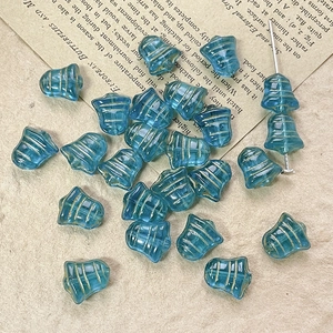 Blue glass bell beads with gold stripes for DIY jewelry making on vintage paper