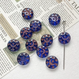 Detailed view of dark blue Czech glass beads with hand-painted copper star and moon motifs