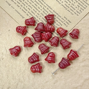 Macro shot of red bell-shaped glass beads for DIY jewelry making on vintage paper
