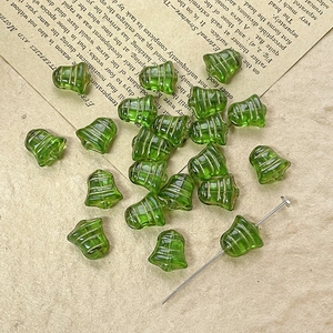 Close-up of green bell-shaped Czech glass beads with gold stripes for DIY jewelry making