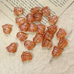Macro shot of amber glass bell beads with grooved texture on a vintage paper background