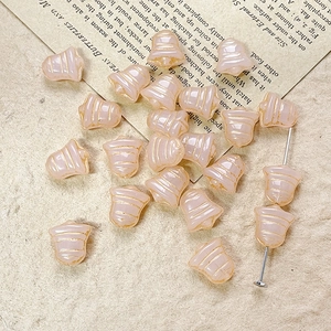 Detailed macro view of pink bell-shaped glass beads with gold stripes for DIY jewelry making