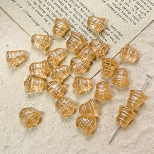 Macro detail of amber glass bell beads on vintage paper for DIY jewelry making