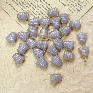 Detail of lilac bell-shaped Czech glass beads with golden grooves for DIY jewelry making