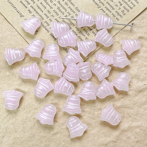 Close-up of light pink bell-shaped Czech glass beads for DIY vintage jewelry making