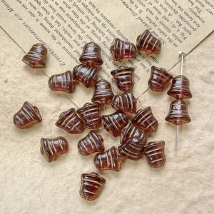 Macro detail of dark brown bell-shaped glass beads with gold stripes on vintage paper