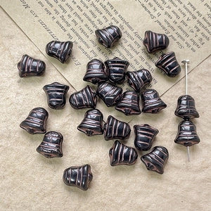 Macro shot of black and bronze bell-shaped Czech glass beads for DIY jewelry making