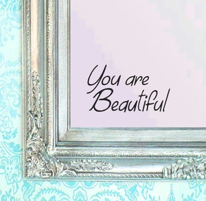Detail of 'You are Beautiful' wall sticker on a silver embossed mirror frame surface