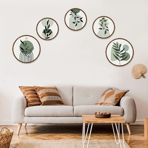 Bohemian style set of 5 round wooden wall art featuring green botanical leaf patterns