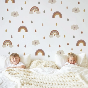 Detail of bohemian rainbow and heart clouds wall stickers in a cozy nursery bedroom