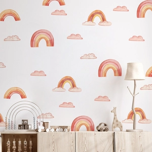 Detail of watercolor rainbow and pink cloud wall stickers in a cozy nursery playroom