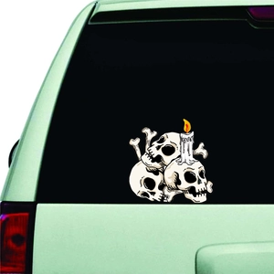 Detail of Halloween car sticker with stacked skulls and lit candle on rear window