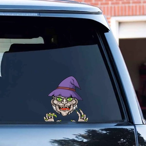 Detailed view of a green-faced cartoon witch sticker applied to a car's rear window glass