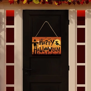 Halloween wooden sign with scarecrow and pumpkins hanging on dark door with maple leaves