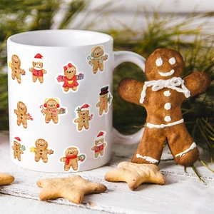 White ceramic Christmas mug featuring various cute gingerbread men with pine branches