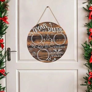 Round wooden Treats for Santa sign hanging on a white door with Christmas wreaths