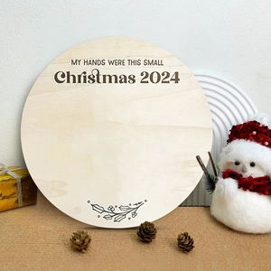Runde hölzerne Weihnachts-Meilensteinkarte 2024 für Baby-Handabdrücke mit Deko