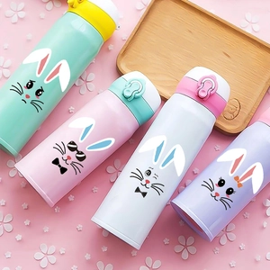 Gros plan de gourdes isothermes pastel ornées d'autocollants et de motifs de lapins mignons