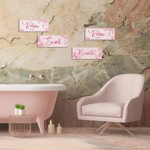 Détail de quatre plaques de salle de bain roses Relax Soak Breathe sur mur marbre