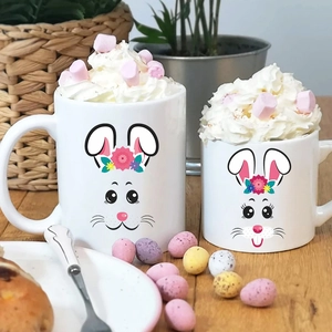 Set of two white ceramic Easter bunny mugs with floral wreaths in a cozy home setting