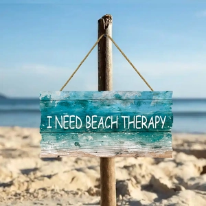 Rustic blue wooden beach therapy hanging sign with rope on a sunny beach background