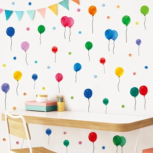 Detailed view of watercolor hot air balloon and polka dot wall stickers in a nursery setup