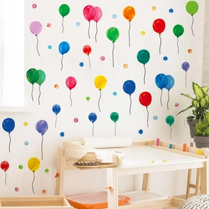 Detail of watercolor balloon wall stickers on white nursery wall with wooden desk
