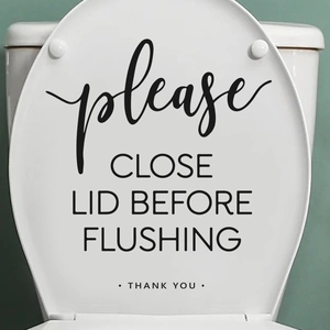 Close-up of black vinyl toilet lid decal with Please close the lid before flushing text