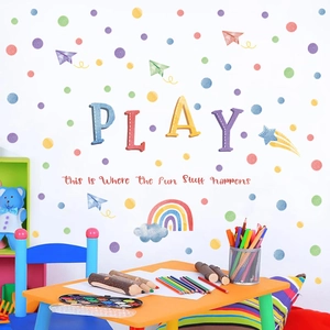 Detail of colorful polka dots, rainbows and 'PLAY' typography wall decals in a playroom