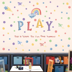 Detail of colorful wall decals with PLAY lettering, rainbows, and planes for kids rooms