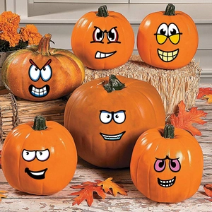 Set of six Halloween decorative pumpkins with funny cartoon face stickers and autumn leaves