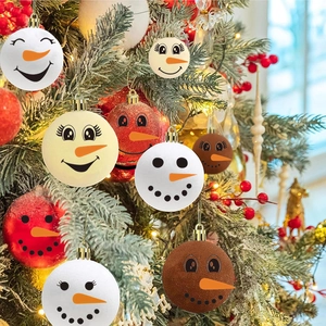Close-up of colorful Christmas snowman face ornaments hanging on a festive pine tree