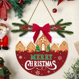 Round wooden Merry Christmas door sign with gingerbread house, red bow and green pine decor