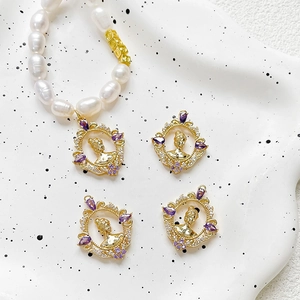 Detail of vintage gold-plated lady portrait charms with purple zircons on pearl bracelet