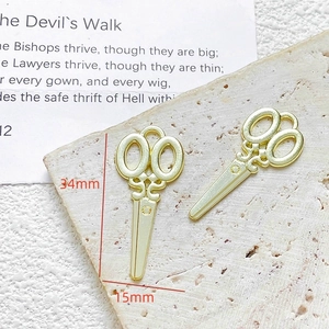 Detail van twee gouden schaarhangers van 34mm bij 15mm voor DIY-sieraden maken