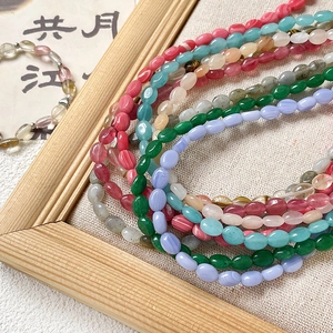 Perles plates en pierres naturelles colorées pour création de bijoux DIY sur fond de lin