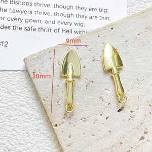 Detail van een gouden schop-hanger voor sieraden met afmetingen van 30 mm hoogte en 9 mm breedte