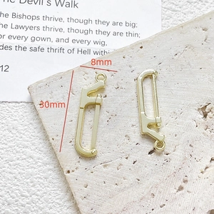 Gedetailleerde macro-opname van twee gouden mini-metaalzaagbedels voor DIY-sieraden