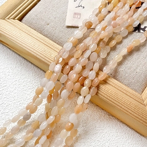 Vue macro de perles d'agate naturelles ovales au lustre huileux sur fond de lin rustique
