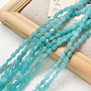 Gros plan de perles ovales en pierre naturelle bleu clair translucide pour bijoux DIY