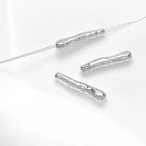 Macro shot of silver textured bar beads with irregular organic finish for DIY jewelry